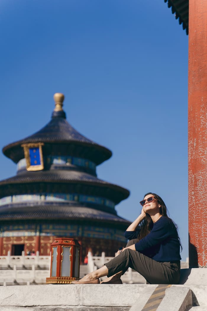 señora tomandose una foto en china de fondo de fondo un edificio cultural chino